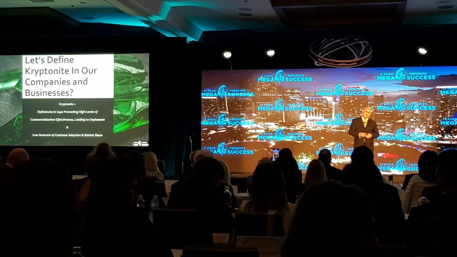 Craig T. Ingram on stage at MegaSuccess, beside his slide defining commercialization kryptonite